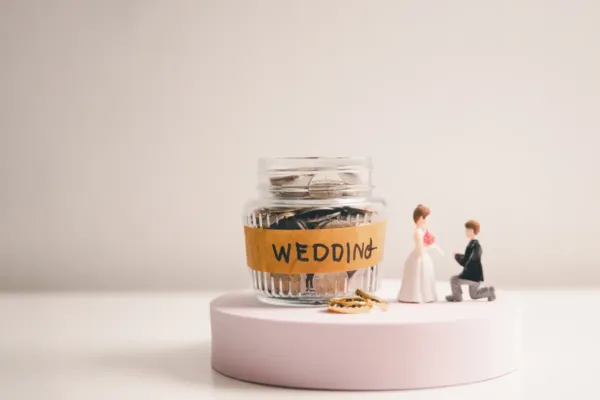 Savings Jar Labeled For Wedding Expenses Representing Practical Money Saving Tips For Your Wedding And Structured Financial Planning