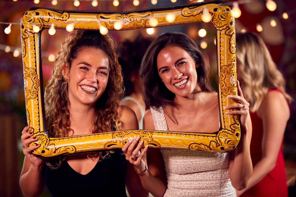 Guests posing with a decorative photo frame, showing interactive décor as part of 2025 wedding trends.