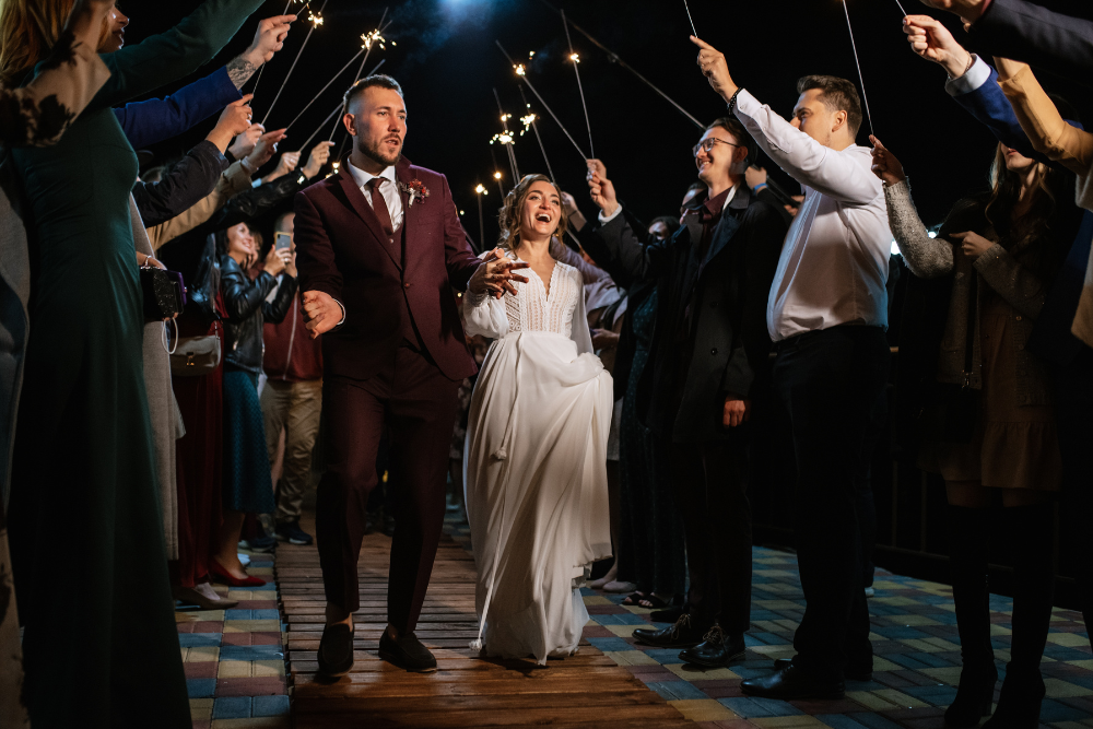 Couple walking through sparkler exit, a wedding trend in 2025 for memorable receptions.